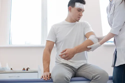 Injured man having his elbow wrapped