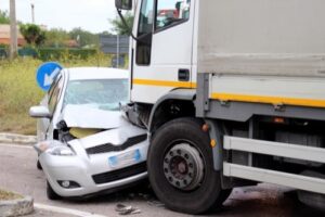 Car damaged in collision with commercial truck