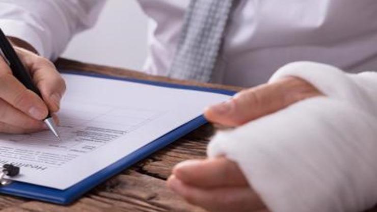 A man with an injured form reviewing legal forms