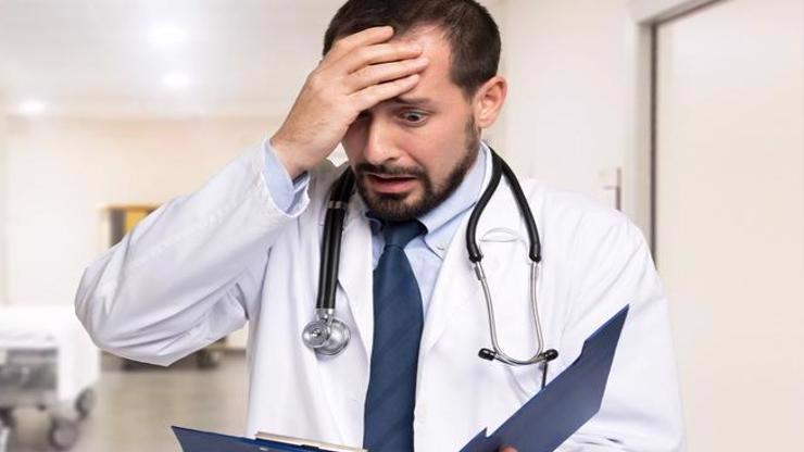 A doctor reading a notebook realizing he has made a mistake.