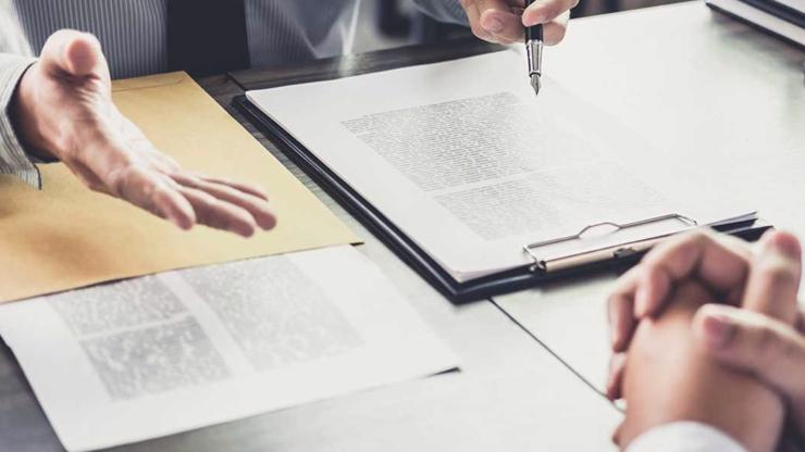 Two people meeting at a desk reviewing legal forms