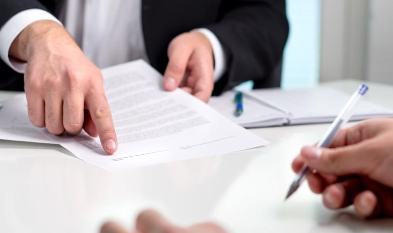 Two people at a desk reviewing a legal document.